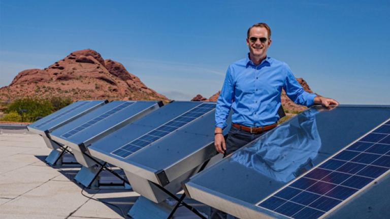 Cody Friesen standing by an installed row of installed solar-powered water harvesters