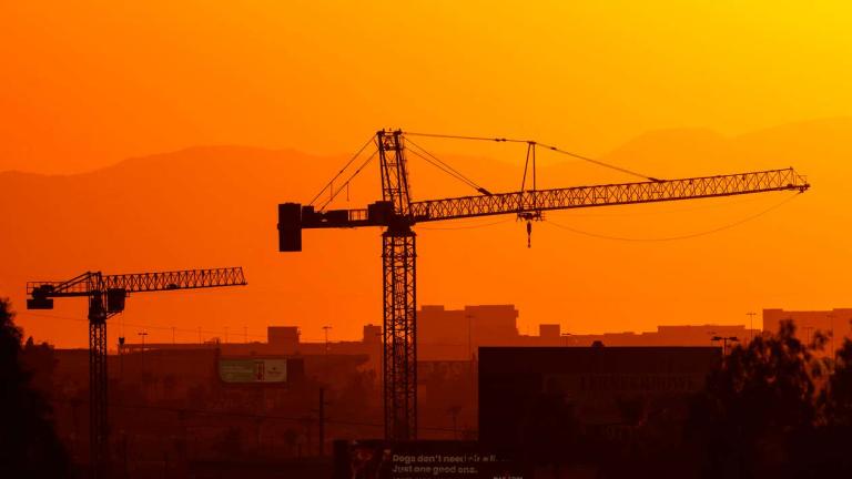 Construction cranes in Phoenix on July 13, 2023, the 14th day in a row of temperatures 110 degrees or more.