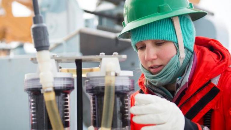 Lauren Kipp inspecting laboratory equipment