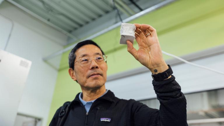 Professor Yet-Ming Chiang holds a mechanical test specimen of decarbonized cement.