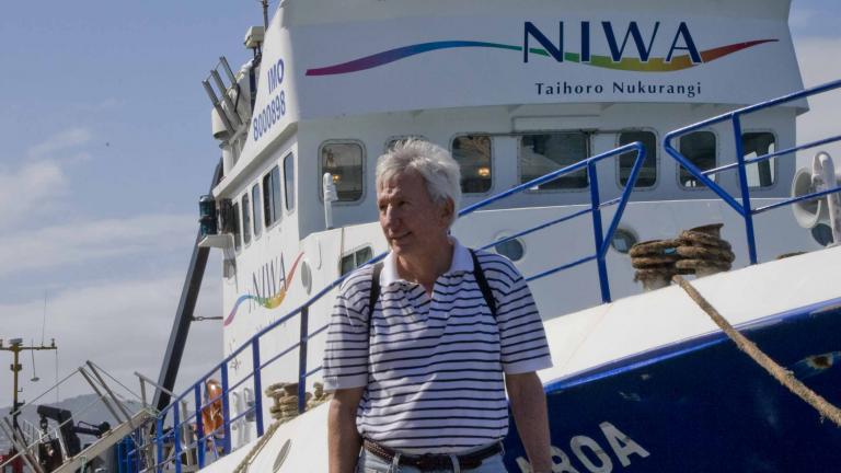 Dean Roemmich in front of a boat in New Zealand 