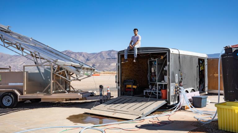 Jon Bessette sits atop a trailer housing the electrodialysis desalination system at the Brackish Groundwater National Desalination Research Facility (BGNDRF) in Alamogordo, New Mexico. The system is connected to real groundwater, water tanks, and solar panels. 