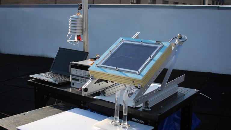 A prototype of the new two-stage water harvesting system (center right), was tested on an MIT rooftop. The device, which was connected to a laptop for data collection and was mounted at an angle to face the sun, has a black solar collecting plate at the top, and the water it produced flowed into two tubes at bottom. 