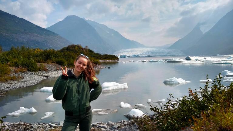 Tchelet Segev stands in front of an ice lake 