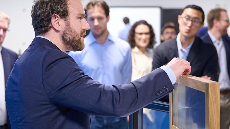 At an event marking the opening of AeroShield's new pilot manufacturing facility in Waltham, Massachusetts, Aaron Baskerville-Bridges, co-founder and vice president of operations, shows an AeroShield prototype window with the ability to cut energy losses in half.