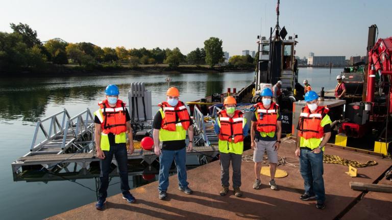 Left to right: Stephen Murray, Jason Valenzano, David Kindler, Paul Ryu, and Andrew March deploy their 8 m × 8 m sonar array test bed, held together by a metal frame, in Boston Harbor for sea tests. 