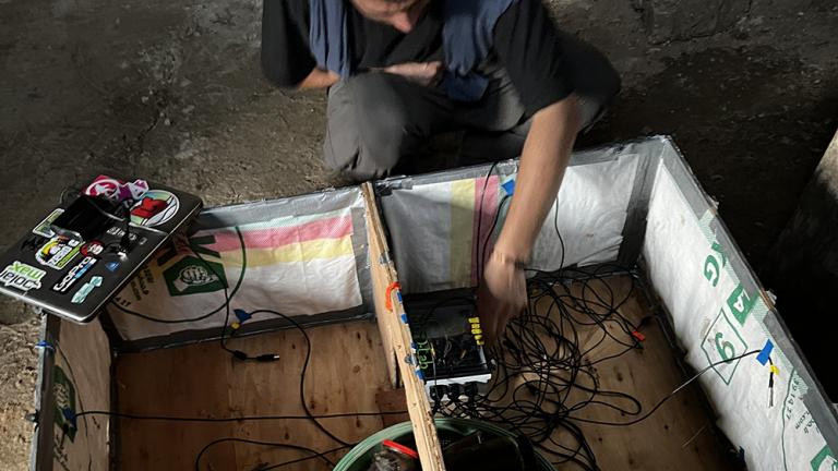 MIT D-Lab instructor Ahmad Zakka sets up a thermal sensor in a new low-cost brooder box located at the African Diaspora Council of Switzerland – Branch Cameroon (CDAS–BC)-operated farm in Afambassi, Cameroon. 