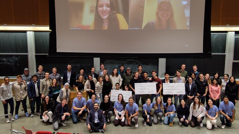 Energy and Climate Hack participants, in person and virtually, gather for a photo.