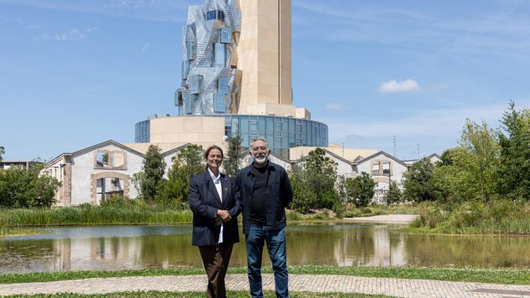 Maja Hoffmann (left), founder and president of the LUMA Foundation, and Hashim Sarkis, dean of the MIT School of Architecture and Planning, at LUMA Arles in the Parc des Ateliers in France. This 27-acre interdisciplinary campus is an experimental site of exhibitions, artists’ residencies, research laboratories, and educational programs that includes The Tower, a multipurpose space designed by Frank Gehry, seen here amid 19th-century factory buildings.