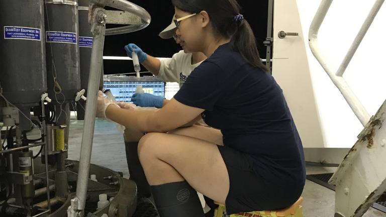 Tianyi Huang takes seawater samples from Niskin bottles.