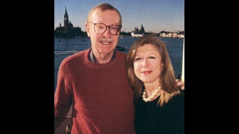 On the left is Peter stone in a red sweater, with his arm around Paola Malanotte-Rizzoli in a black shirt. Behind them in a distant view of some buildings in Venice