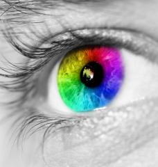 Photo of human eye with the iris in a rainbow of colors.