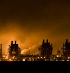 Nighttime photo of power generation plant buildings with fog and backlighting.