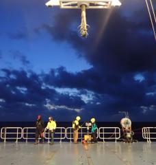 Scientists prepare to deploy an underway CTD from the back deck of a research vessel.