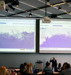 Professor John Sterman displays maps showing the consequences of sea-level rise on various coastal cities, as part of the “SimPlanet” event at MIT.