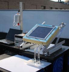 A prototype of the new two-stage water harvesting system (center right), was tested on an MIT rooftop. The device, which was connected to a laptop for data collection and was mounted at an angle to face the sun, has a black solar collecting plate at the top, and the water it produced flowed into two tubes at bottom. 