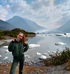 Tchelet Segev stands in front of an ice lake 