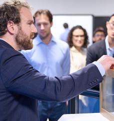 At an event marking the opening of AeroShield's new pilot manufacturing facility in Waltham, Massachusetts, Aaron Baskerville-Bridges, co-founder and vice president of operations, shows an AeroShield prototype window with the ability to cut energy losses in half.