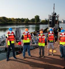 Left to right: Stephen Murray, Jason Valenzano, David Kindler, Paul Ryu, and Andrew March deploy their 8 m × 8 m sonar array test bed, held together by a metal frame, in Boston Harbor for sea tests. 