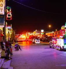 Residents and visitors watch as the city float drives by in the annual light parade in Helper, Utah.