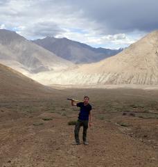 Craig Martin holds a pickaxe in the Himalayan mountains.