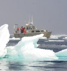 A research vessel and chunks of ice floating in the Arctic Ocean